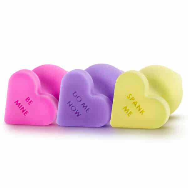 Candy Hearts silicone butt plugs in pink, purple, and yellow